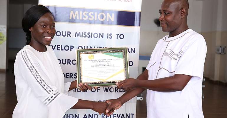 Ms. Jennifer Yeboaa (left) presenting the Humanity award to Dr. Thomas Buabeng