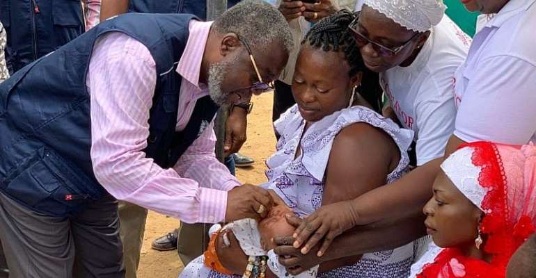 The Director-General of the Ghana Health Service, Anthony Nsiah-Asare, vaccinating the first child in Greater Accra to kickstart the response vaccination against polio. 