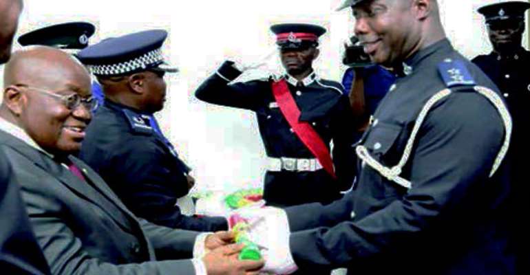 President Akufo-Addo presenting a parchment to ASP Francis Okuntey at the graduation ceremony