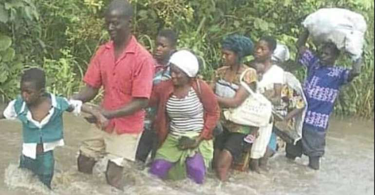 Commuters wading through the over flowing river