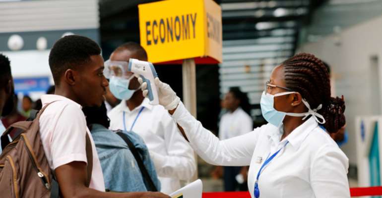 File: A health worker checks the temperature of a traveller as part of the coronavirus screening procedure at the Kotoka International Airport in Accra.