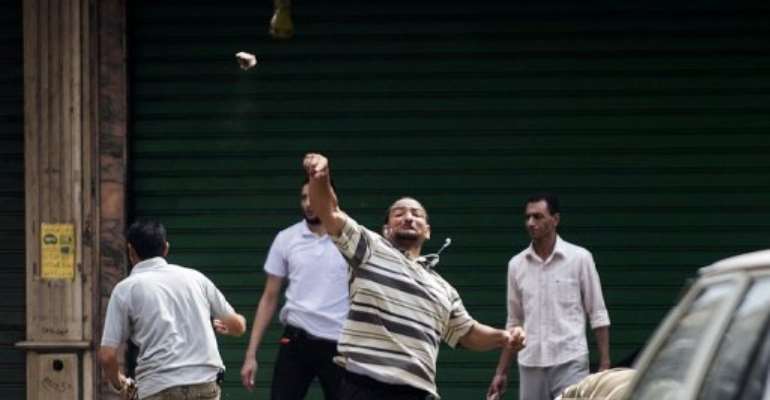 A supporter of ousted president Mohamed Morsi throws stones, in Cairo, on August 13, 2013. By Gianluigi Guercia (AFP)