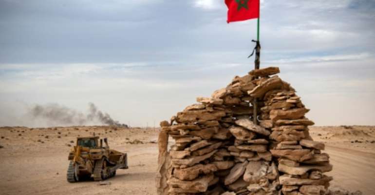 A bulldozer passes by a hilltop manned by Moroccan soldiers on a road between Morocco and Mauritania in Guerguerat located in the Western Sahara, on November 23. By Fadel SENNA (AFP)