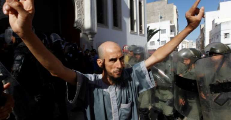 A demonstrator gestures in front of Moroccan security forces during a march in the northern Moroccan city of Al-Hoceima on July 20, 2017 in defiance of a government ban. By STRINGER (AFP/File)