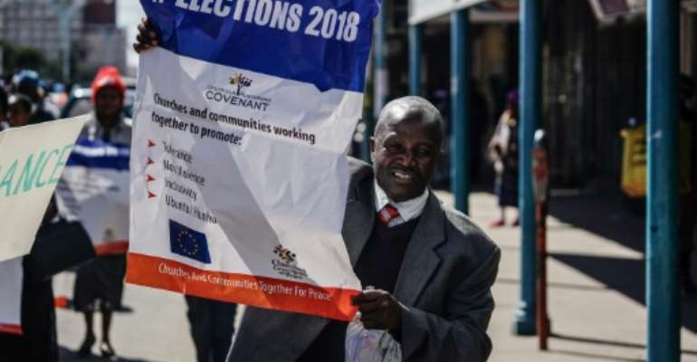 A demonstrator holds a banner as he takes part in a march for peace, staged by Zimbabwean churches on Thursday. By ZINYANGE AUNTONY (AFP)