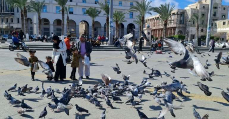 A family feeds pigeons in Libya's capital Tripoli on Tuesday, as politicians discussed the future structures of government in a bid to build peace in the long-troubled nation. By Mahmud TURKIA (AFP)