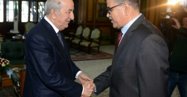 A handout picture released by the official Algeria Press Service (APS) shows Algerian President Abdelaziz Tebboune (L) receiving the newly appointed Prime Minister Abdelaziz Djerad in the capital Algiers on December 28, 2019. By - (APS/AFP/File)