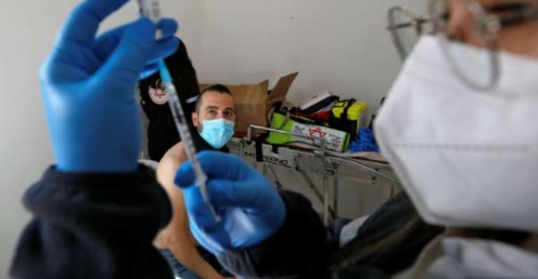 A health worker prepares a dose of the Pfizer-BioNtech vaccine on February 22, 2021 in Israel, which maintains a tight blockade on Gaza, where some 20,000 Russian-made Sputnik V vaccine doses have arrived from the United Arab Emirates. By JALAA MAREY (AFP)