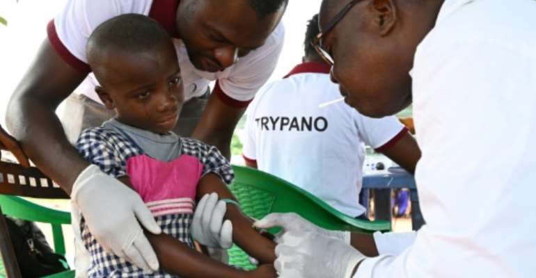 A health worker takes blood from a child in the Ivorian village of Paanenefla -- the sample will be tested for sleeping sickness. By ISSOUF SANOGO (AFP)