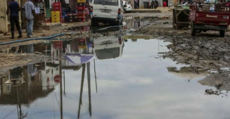 A large puddle of stagnant water sits in the roadway in a slum in Luanda, Angola in February 2018 following heavy rain. By AMPE ROGERIO (AFP)