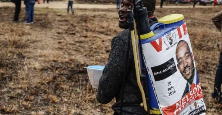 A man on his way to an election rally on July 7 with a campaign poster featuring Movement for Democratic Change Alliance leader Nelson Chamisa. By ZINYANGE AUNTONY (AFP/File)