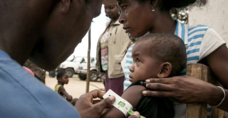 A member of the NGO Action Against Hunger measures the arm circumference of infants in Ifotoka to monitor for malnutrition (2018 file picture). By RIJASOLO (AFP/File)