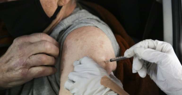 A patient receives a drive-up COVID-19 vaccination in the US state of Washington as the country tries to get on top of its massive virus outbreak. By Jason Redmond (AFP)