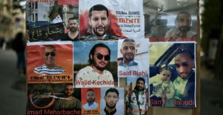 A poster shows portraits of Algerian detainees, including Walid Kechida -- a supporter of Algeria's Hirak protest movement -- outside the Algerian embassy in Paris during a demonstration in August 2020. By STEPHANE DE SAKUTIN (AFP/File)