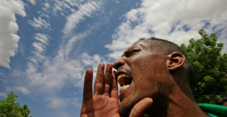 A Sudanese protester calls for justice on the one-year anniversary of the formation of a transitional government. By ASHRAF SHAZLY (AFP)
