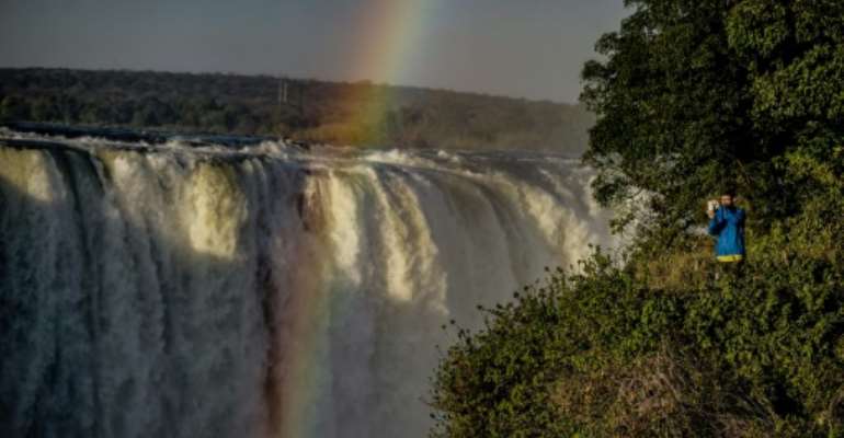 A tourist takes a photograph of the rainbow over Victoria Falls in Zimbabwe, where the number of tourists jumped by nearly 50 percent in the first quarter of tis year. By Zinyange AUNTONY (AFP)
