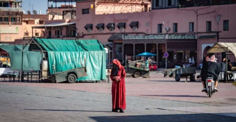 A woman crosses the legendary Jemaa el-Fna square in the Moroccan city of Marrakesh, currently empty of its usual crowds due to the Covid-19 pandemic. By FADEL SENNA (AFP/File)