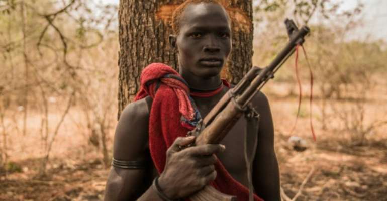 A young herdsman from the Dinka tribe poses with a semi-automatic weapon. Guns are rife in rural South Sudan, for self-protection or defence against cattle raiders. By Stefanie GLINSKI (AFP)
