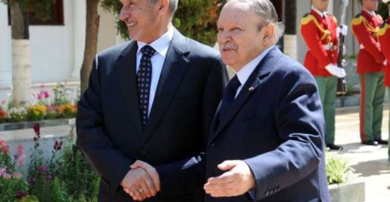 Libyan leader Mustafa Abdel Jalil (L) shakes hands with Algerian President Abdelaziz Bouteflika. By Farouk Batiche (AFP)