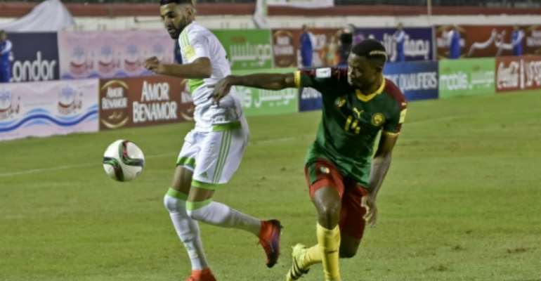 Algeria's Riyad Mahrez (L) fights for the ball with Cameroon's Aurelien Chedjou during their FIFA World Cup 2018 qualifying match at Stade Tchakert in Blida, on October 9, 2016. By RYAD KRAMDI (AFP/File)