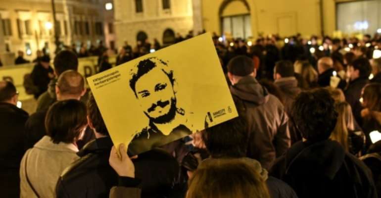Amnesty International activists hold a picture of student Giulio Regeni who was murdered in Egypt as they take part in a demonstration in front of the Italian Parliament in Rome in January 2017 a year after his killing. By ANDREAS SOLARO (AFP/File)