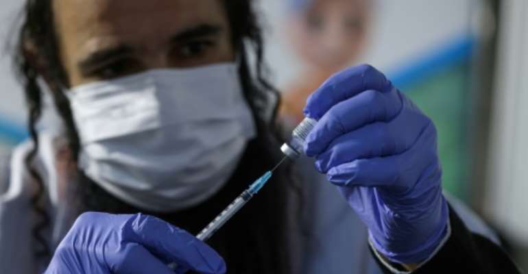 An Israeli health worker prepared a dose of the Pfizer-BioNTech Covid-19 vaccine at Clalit Health Services in Jerusalem earlier this month as part of a vaccination campaign considered one of the largest in the world to date. By MENAHEM KAHANA (AFP)