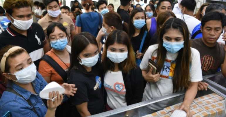 Anxious shoppers try to buy face masks in Manila after the first foreign fatality from the new coronavirus was reported in the Philippines. By Ted ALJIBE (AFP)