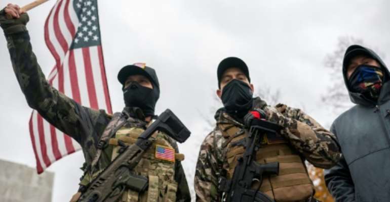 Armed protesters wave the US flag as they allege that President Donald Trump is being cheated out of an election victory in a November 14, 2020 rally in Salem, Oregon. By Nathan Howard (GETTY IMAGES NORTH AMERICA/AFP/File)