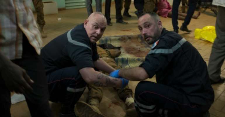 French first responders tend to wounded people in the surroundings of the Splendid htel and the café Cappuccino during the attack in Ougadougou on January 15, 2016. By Nabila El Hadad (AFP)