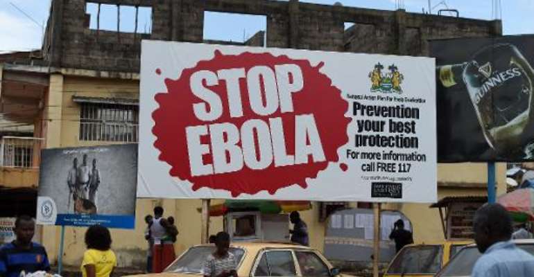 People walking past a billboard reading