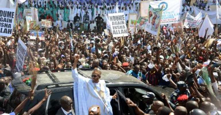 Leading opposition All Progressives Congress presidential candidate Mohammadu Buhari (C) raises his hand during a campaign rally in Maiduguri, on February 16, 2015. By Olatunji Omirin (AFP/File)