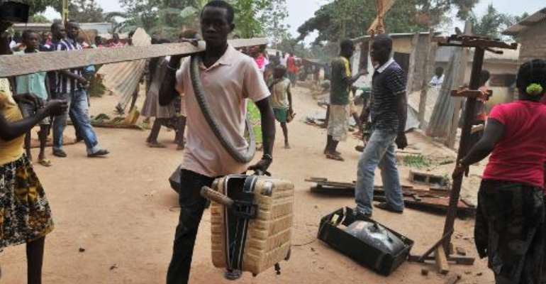 Looters steel objects from the homes of Muslim residents of Bangui, Central African Republic, after the departure of ex-Seleka Muslim rebels from the Kasai military camp to another camp outside the city on January 28, 2014. By Issouf Sanogo (AFP)