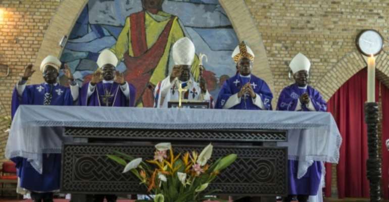 Cardinal Laurent Monsengwo Pasinya (C), Archbishop of Kinshasa and a leading government critic, passed the baton to Fridolin Ambongo, who will take over as de facto leader of the Democratic Republic of Congo's powerful Catholic Church. By EDUARDO SOTERAS (AFP)