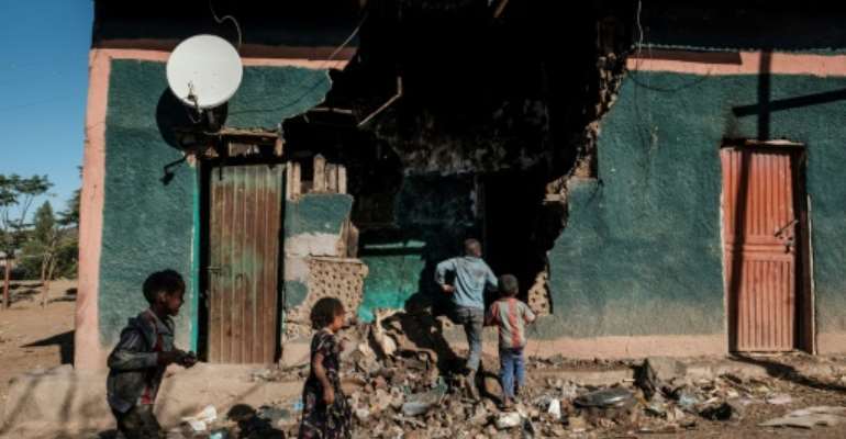 Children play in front of a house that was damaged during the fightings that broke out in Ethiopia's Tigray region, in the village of Bisober, on December 9, 2020. By EDUARDO SOTERAS (AFP/File)