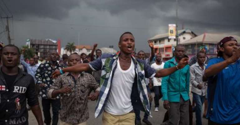 APC party supporters march towards the Independent National Electoral Commission Office in Port Harcourt, Nigeria, calling for the cancellation of the Presidential elections in the Rivers State on March 29, 2015. By Florian Plaucheur (AFP/File)