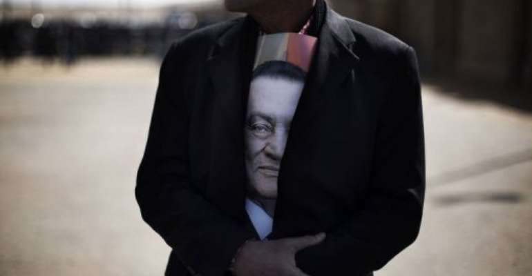 A supporter of ousted Egyptian president Hosni Mubarak outside the court in Cairo. By Marco Longari (AFP)
