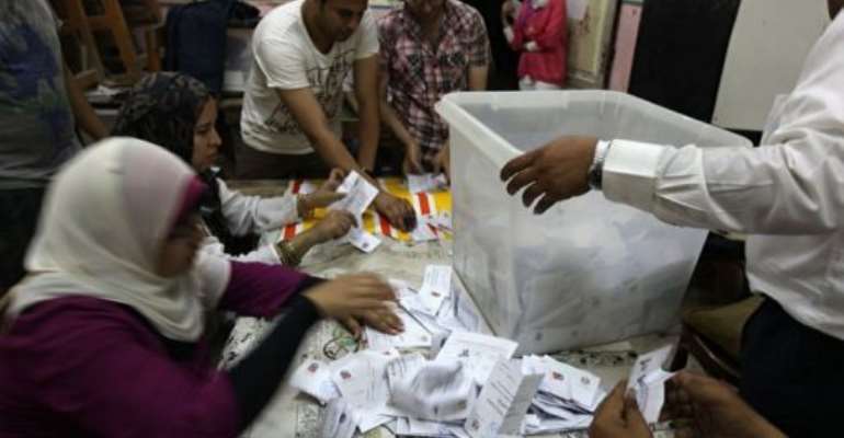 Egyptian election officials counts vote at a polling station in Cairo. By Patrick Baz (AFP)