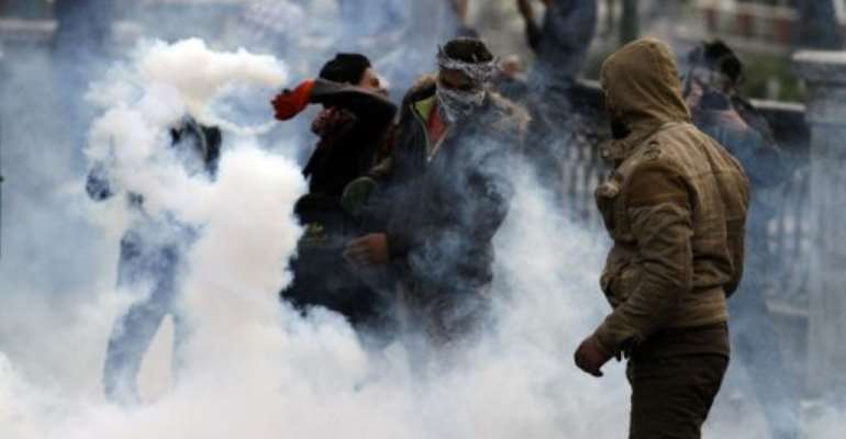 An Egyptian protester throws a tear gas canister back towards riot police during clashes in Cairo on January 29, 2013. By Mohammed Abed (AFP)