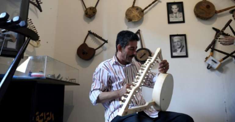 Egyptian craftsman Mohamed Ghaly adds the finishing touches on a semsemia that he made at the Canal 20 cultural museum in Port Said which he founded to pass on the musical heritage to a new generation. By Khaled DESOUKI (AFP)