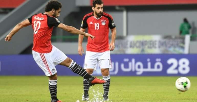 Egypt's forward Mohamed Salah (L) takes a free kick to score a goal during the 2017 Africa Cup of Nations group D football match against Ghana in Port-Gentil on January 25, 2017. By Justin TALLIS (AFP)