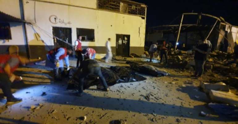 Emergency workers recover bodies after an air strike on a migrant detention centre in Libya. By Mahmud TURKIA (AFP)