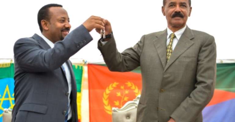 Ethiopian Prime Minister Abiy Ahmed (left) and Eritrean President Isaias Afwerki celebrate the reopening of the Embassy of Eritrea in Ethiopia in Addis Ababa on July 16, 2018. By MICHAEL TEWELDE (AFP/File)