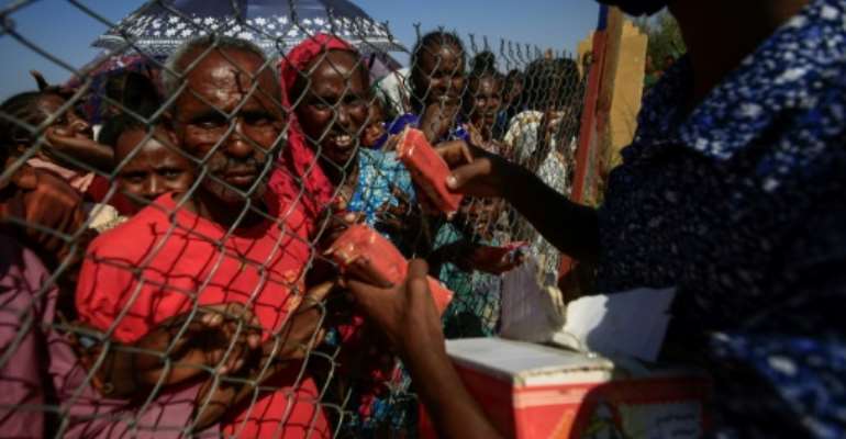 Ethiopian refugees who fled fighting in the Tigray region receive food at the 'Village 8' reception center in Sudan's eastern Gedaref state. By ASHRAF SHAZLY (AFP)