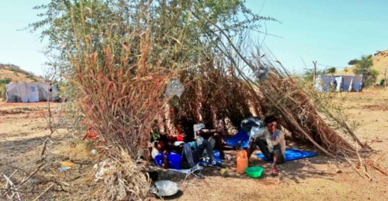 Ethiopian refugees who fled fighting in Tigray province lay in the shade in a straw shack at the Um Rakuba camp in Sudan's eastern Gedaref province, on November 18, 2020. By Ebrahim HAMID (AFP)