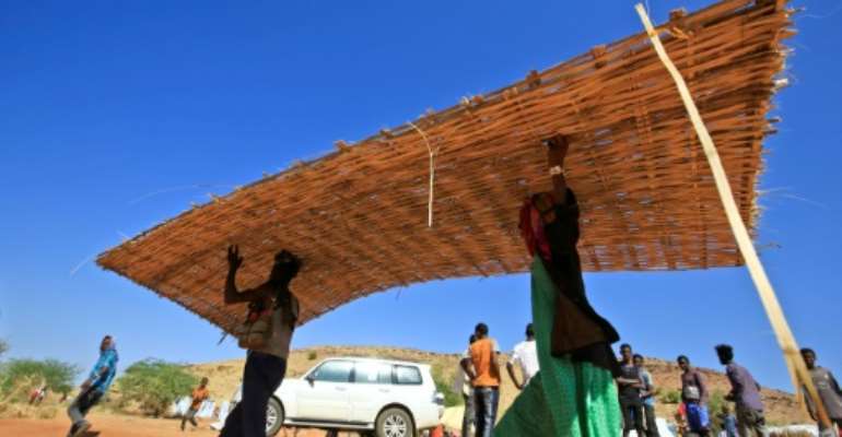 Ethiopian refugees who fled the Tigray conflict build huts in Sudan's Um Raquba camp. By ASHRAF SHAZLY (AFP)