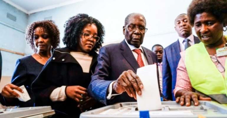 Former Zimbabwean president Robert Mugabe (C), his daughter Bona (C) and wife Grace (L) cast their votes at a polling station in the Highfields district of Harare. By Zinyange AUNTONY (AFP)