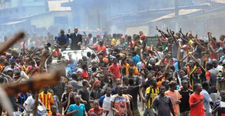 Guinean opposition leader Cellou Dalein Diallo waves on a car surrounded by demonstrators on April 15, 2015. By Cellou Binani (AFP)