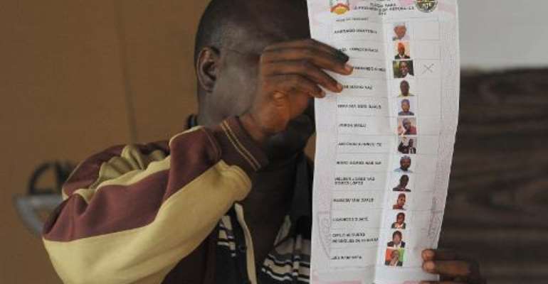 An election official shows a ballot at a polling station in Bissau, Guinea-Bissau, on April 13, 2014. By Seyllou (AFP/File)