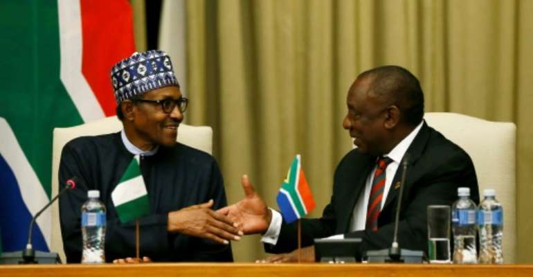 Handshake: Buhari, left, and Ramaphosa. By Phill Magakoe (AFP)