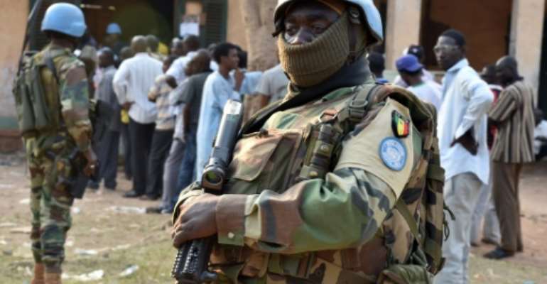 Senegalese UN peacekeeping forces stand guard as people wait to vote at a polling station during presidential and legislative elections in Bangui on December 30, 2015. By Issouf Sanago (AFP)
